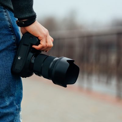 close-up-view-male-hand-holding-professional-camera-street-scaled.jpg